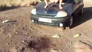 Crazy girl pissing on a black car hood