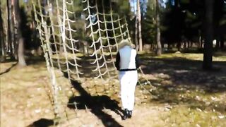 Blonde in a forest squats to take a shit