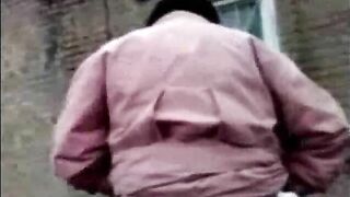 A chubby woman shits in her pants outside