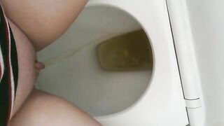 Girl pisses on a toilet full of shit