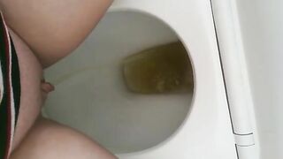 Girl pisses on a toilet full of shit