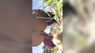 Lady caught shitting in the tall grass