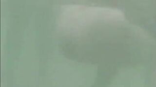 Girl in water plays in her own piss