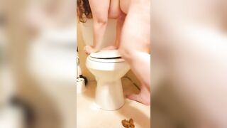 Girl takes a shit on a toilet bowl and spreads it