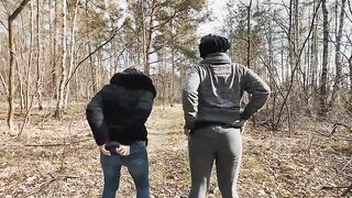 Two chicks bend over and take a dump together in the woods