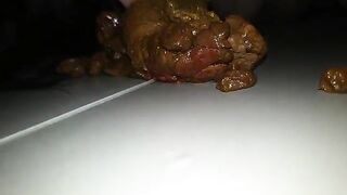 A person takes a massive shit on a plate and then plays with it