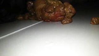 A person takes a massive shit on a plate and then plays with it