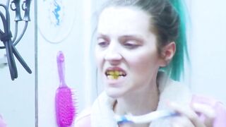 Girl brushes her teeth in the mirror