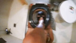 Woman in latex dress shits in a bathroom on a toilet