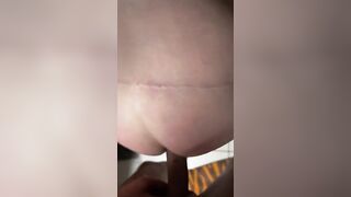 Girl lays on her side while a hand fucks her ass.
