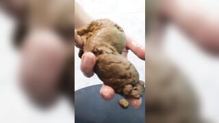 Messy woman pulls a huge shit out of her ass with her hand