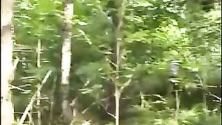 Woman eats shit from the ground in the woods.