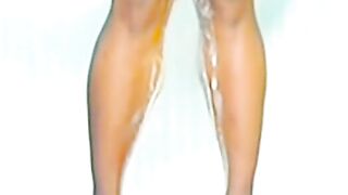 Blonde woman pisses down her legs in the shower
