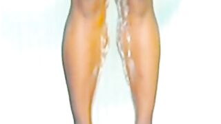 Blonde woman pisses down her legs in the shower