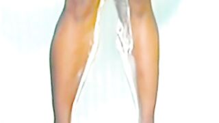 Blonde woman pisses down her legs in the shower