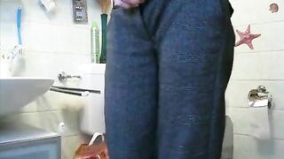 Girl squats over the toilet while another person holds her stomach