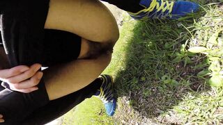 Girl shits on grass while holding up her pants