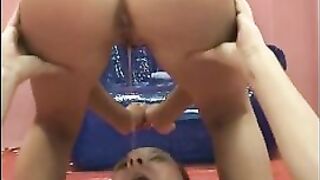 Woman squats over a man's face while holding a blue tarp