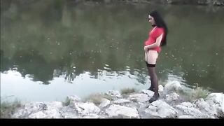 Slut takes a piss out in the open by the river