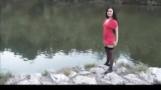 Slut takes a piss out in the open by the river