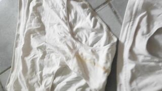 Girl in underwear takes a piss on tiles.