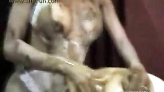 A woman licks shit from another woman's ass while smiling
