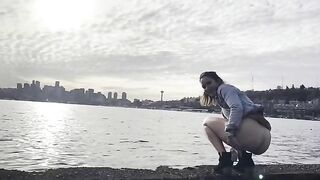 Girl squats to take a shit on the beach