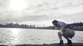 Girl squats to take a shit on the beach