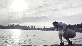 Girl squats to take a shit on the beach