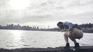 Girl squats to take a shit on the beach