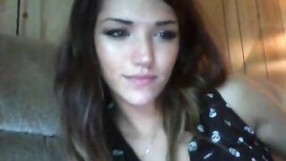 Brunette plays with her ass while sitting on the couch