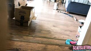 Woman shits on the floor in living room next to boxes