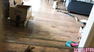 Woman shits on the floor in living room next to boxes