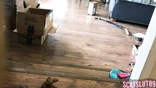 Woman shits on the floor in living room next to boxes
