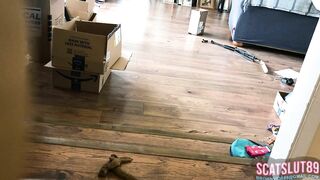 Woman shits on the floor in living room next to boxes
