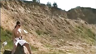 Girl takes a shit on a rock in the dirt