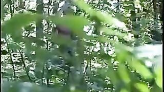 Girl takes a shit on the ground while standing in the woods