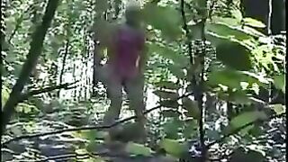 Girl takes a shit on the ground while standing in the woods