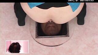Girl squats over a man's head in a box on the floor