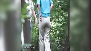 Husband helping wife poop in the forest
