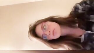 Cute brunette in glasses pooping in toilet