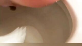 Cute brunette in glasses pooping in toilet